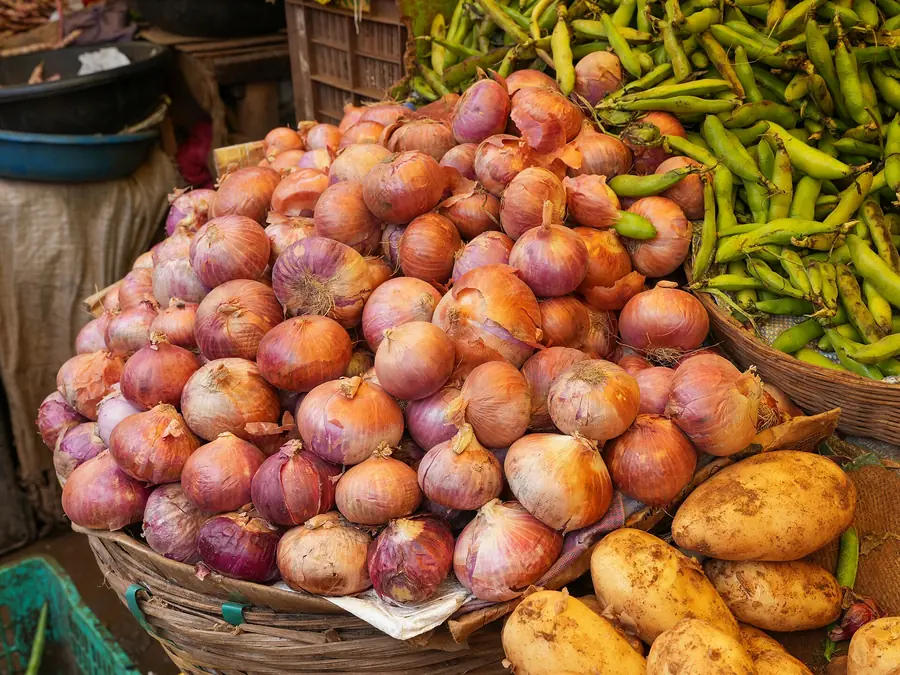 Baskets of onions, beans and potatoes at a wholesale vegetable stall